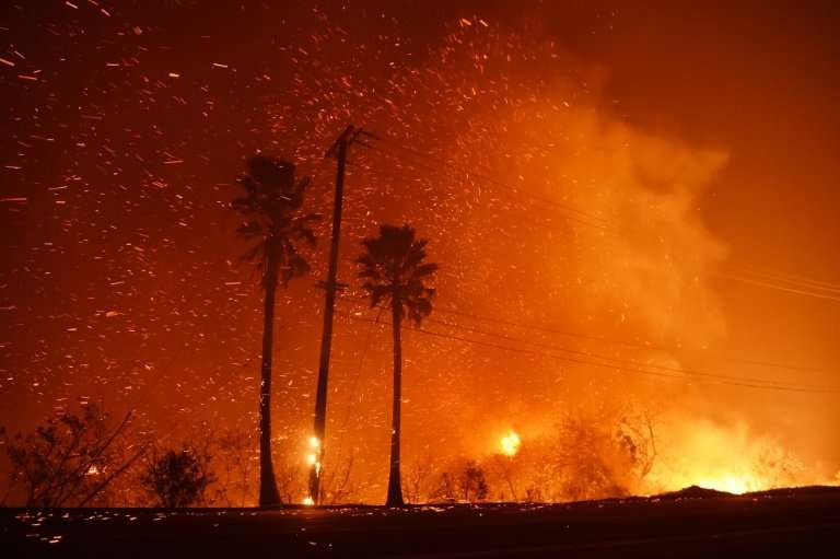 A power line catches fire as the Woolsey fire burns on both sides of Pacific Coast Highway (Highway 1) in Malibu, California, as