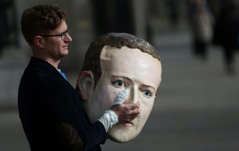 A protestor from the pressure group Avaaz carries a papier mache head of Facebook founder Mark Zuckerberg outside Britain's parl