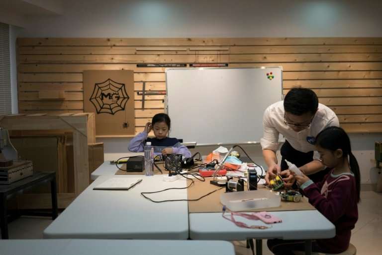 A teacher instructs children at 'MG Space', a small-scale workshop in Shenzhen, southern China