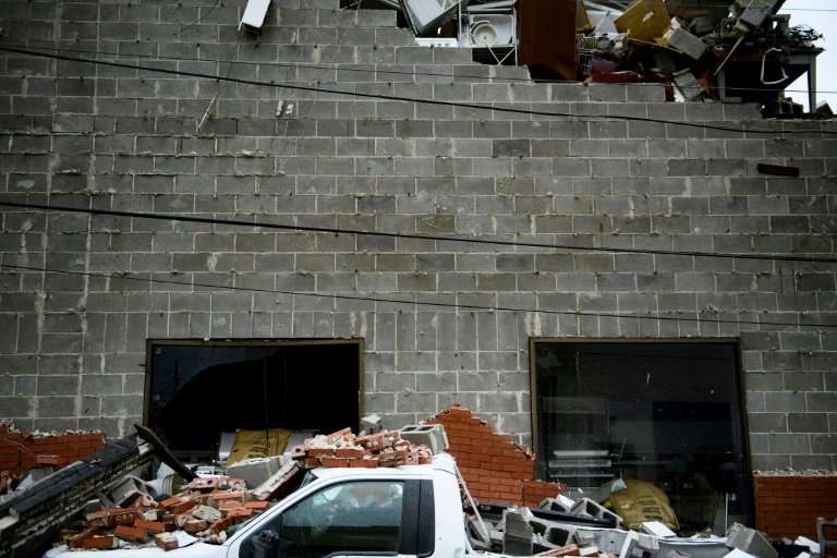 A truck is seen below a partially collapsed wall damaged by Hurricane Michael in Panama City, Florida