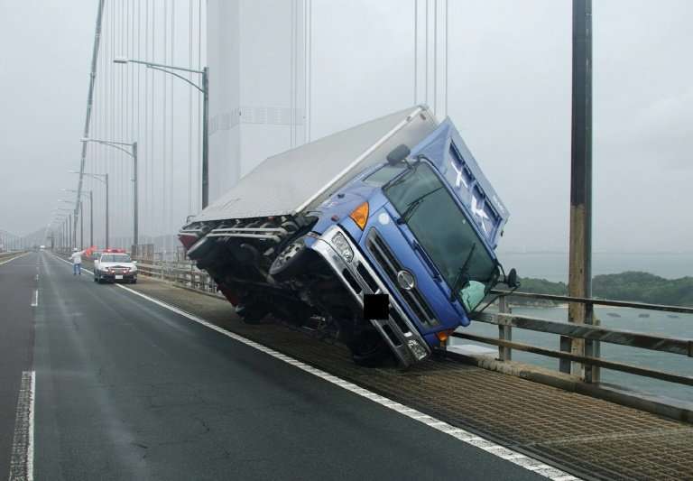 A truck sits at an angle on a bridge after being blown over by strong winds caused by Typhoon Jebi in Sakade, Japan