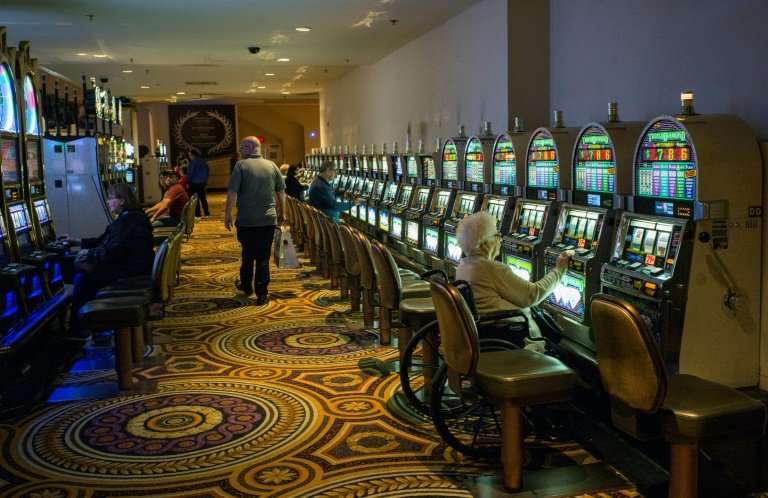 A woman plays the slot machine in a near empty casino in Atlantic City, where the closure of some casinos in recent years contri