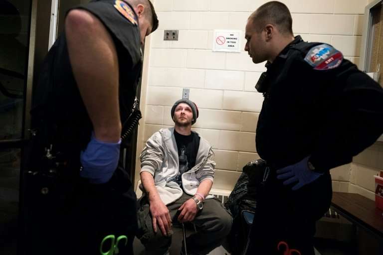 Cody, 31, who fell back into addiction in February, is checked by paramedics as he enters the Safe Station program at the Centra