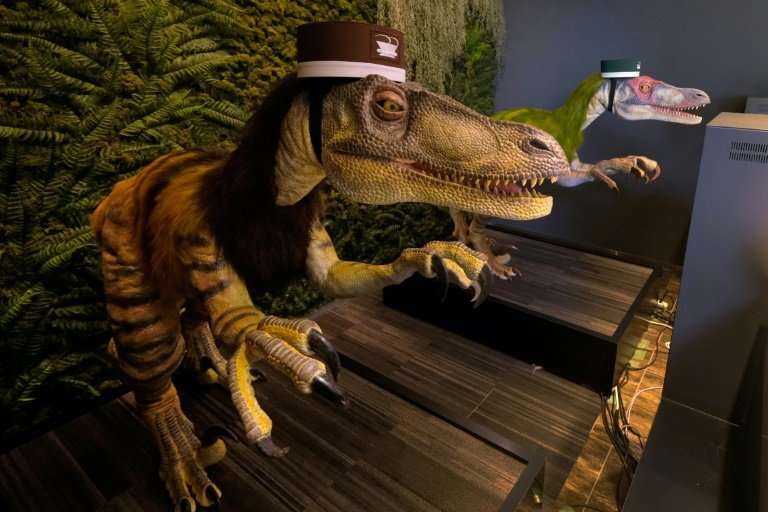 Dinosaur robots wait to check in customers at the Henn na hotel