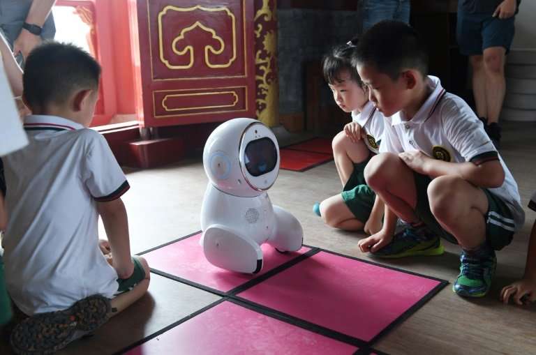 Each time the children get an answer right, the robot reacts with delight, its face flashing heart-shaped eyes