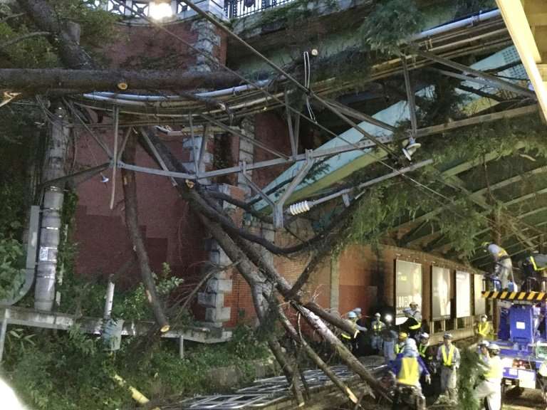 Employees of Japan Rail remove fallen branches from Yotsuya station in Tokyo