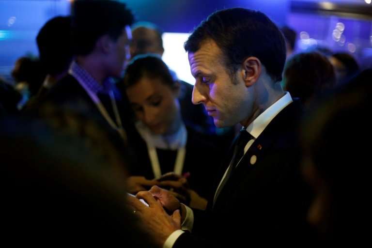 Even French President Emmanuel Macron checks his 'mobile multifonction'.