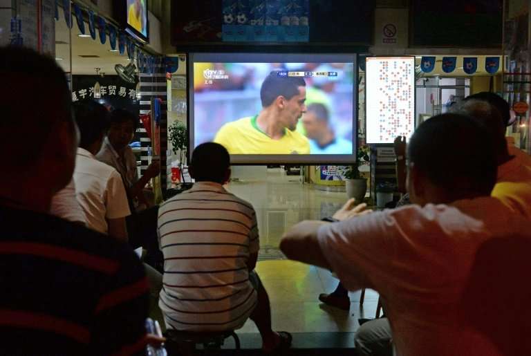 Fans watch the 2018 Russia World Cup round of 16 football match between Brazil and Mexico at a China Sports Lottery outlet in Sh