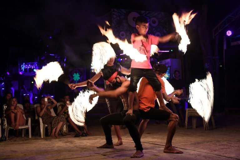 Fire dancers perform for tourists on the southern Thai island of Koh Phi Phi, which is swamped by up to 4,000 daily visitors