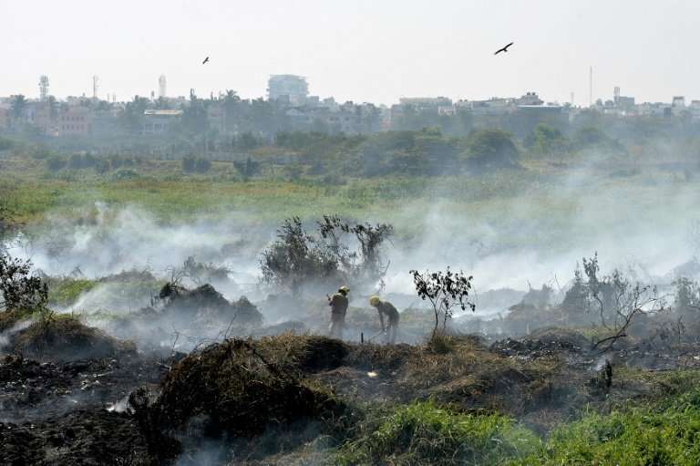 Firefighters work at the polluted Bellandur Lake that has become so toxic it spontaneously catches fire