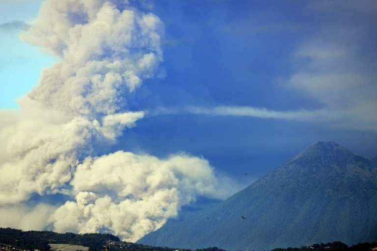 Fuego volcano (L) spews ash, next to Acatenango dormant volcano as seen from Guatemala City on February 01, 2018
