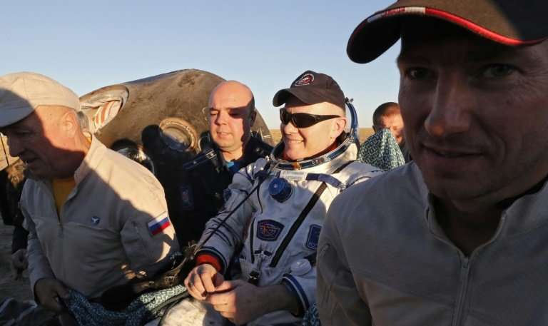 Ground personnel carry Russian cosmonaut Oleg Artemyev shortly after returning to Earth from a six month mission