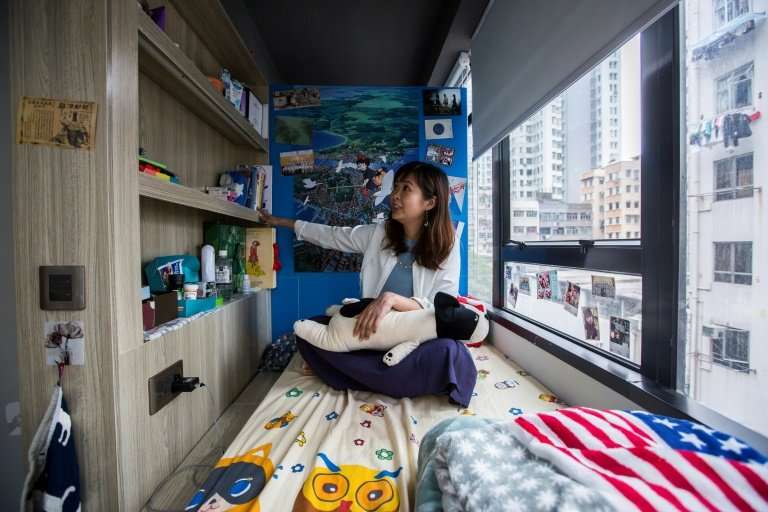 Jezz Ng in a small living space in a co-sharing building in Hong Kong, where box-like 'nano-flats' and co-shares have been toute