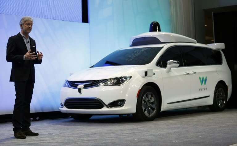 John Krafcik, CEO of Waymo, is seen at the 2017 North American International Auto Show with a customized Chrysler Pacifica Hybri