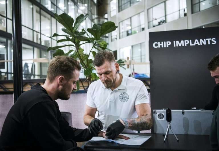 Jowan Osterlund (R), a piercings specialist and self-proclaimed champion of chip implantation, brushes off fears of data misuse 