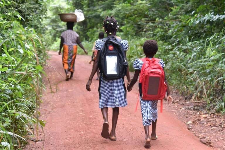 Last year, 13-year-old Lucienne, shown here walking to school with Marie-France, could not go to school at all because their mot