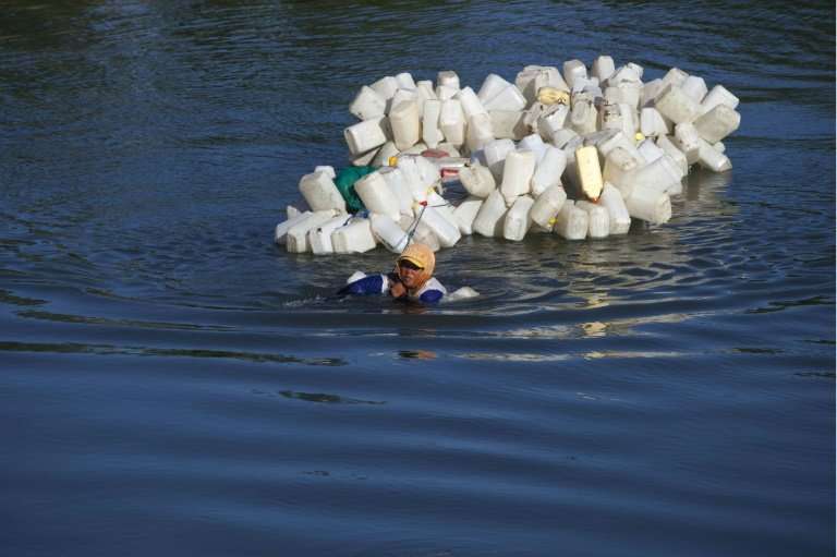 Mama Hasria swims with hundreds of jerry cans to collect clean drinking water for her village