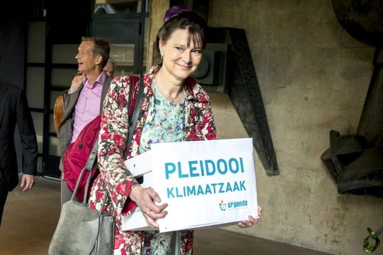 Marjan Minnesma, director of environmental group Urgenda, carries a box saying 'climate case appeal' outside court in The Hague 