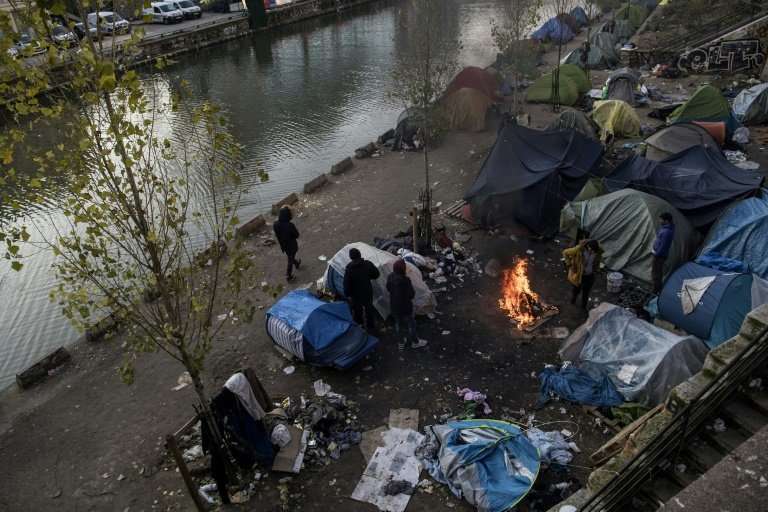 Migrants living in on the streets of Paris struggle to keep themselves warm as temperatures drop below freezing