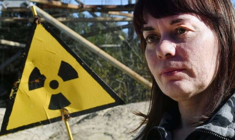Natalia Shevchuk stands by a radioactive sign in the ghost town of Pripyat, as she revisits her abandoned childhood home