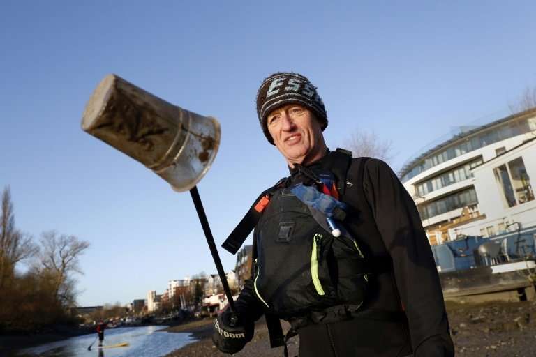 Paul Hyman holds up a plastic cup collected from the Thames