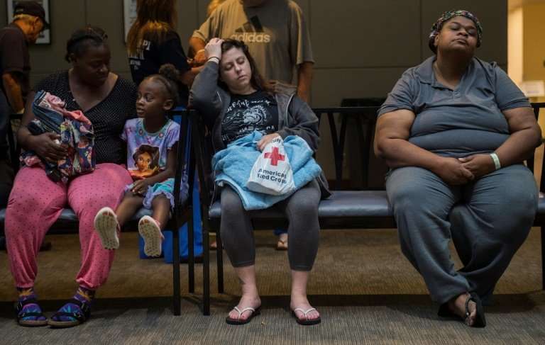 People rest at a Red Cross shelter near Raleigh, North Carolina, while waiting to take a shower, on September 17, 2018