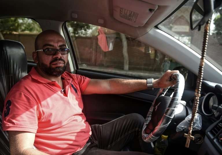 Ramez Wagih, an accountant in the morning and Uber driver in the afternoon, in his car in Cairo
