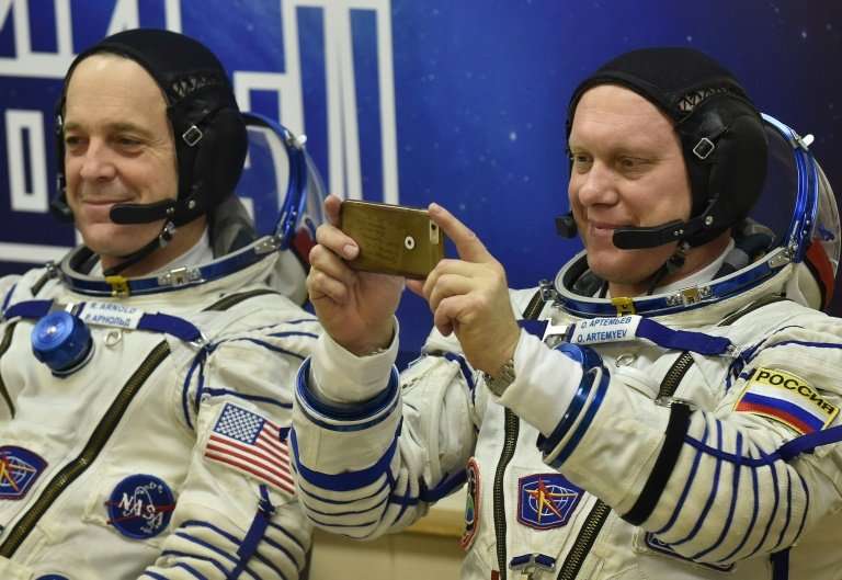 Roscosmos cosmonaut Oleg Artemyev takes a last-minute snap, alongside NASA astronaut Richard Arnold, before they headed into spa