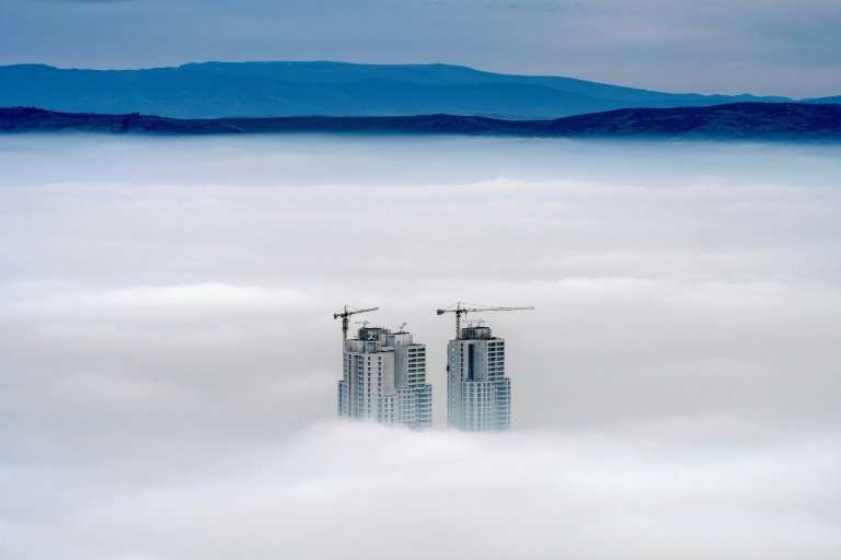Some of the highest buildings in the Skopje area peak above the clouds in an area where the air pollution can practically paraly