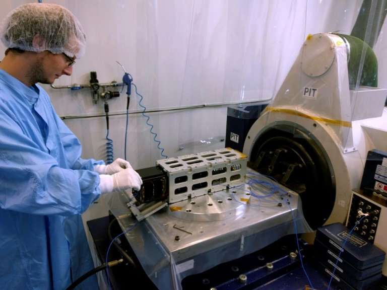System manager Lester David puts the PicSAT Flight model in its launch pod for testing on the vibration table in Saint-Quentin-e