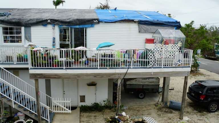 Tarps cover a house with the roof still unrepaired after the damage caused by hurricane Irma in Big Pine Key, Florida