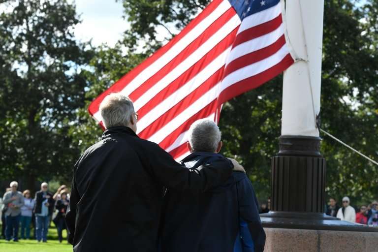 The half-brothers look on as the US flag is raised in the grounds of the Normandy American Cemetery and Memorial at Colleville-s