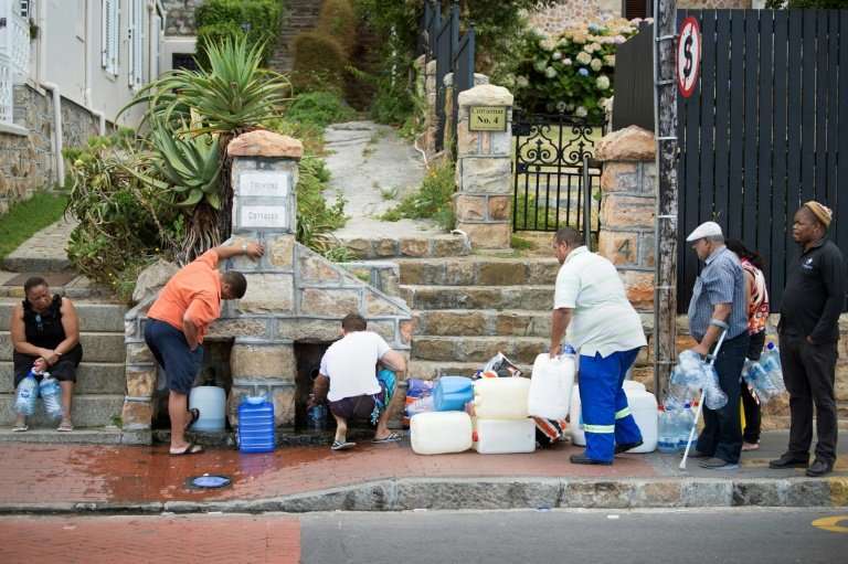 The new normal? People in the Cape Town suburb of St. James queue to collect drinking water from pipes fed by an underground spr