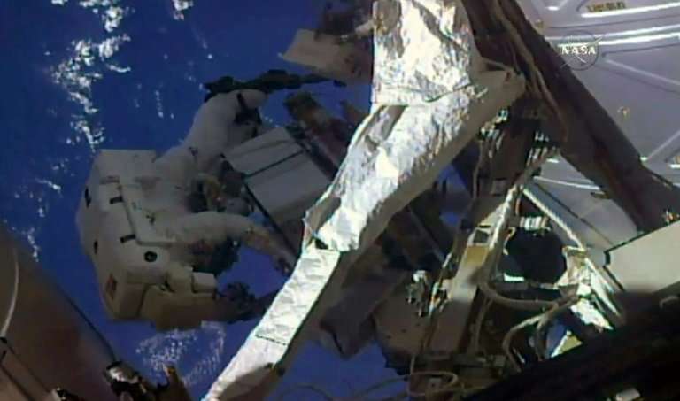 This NASA TV frame grab shows a pair of US astronauts as they began a spacewalk outside the International Space to swap and chec