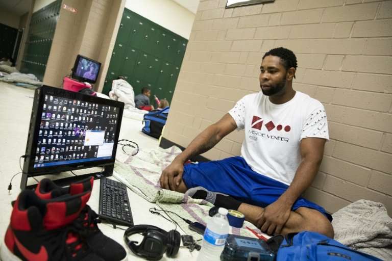 Tony Winborne, 37, looks at a computer in a Hurricane Florence evacuation shelter where, he says, it's &quot;better safe than so
