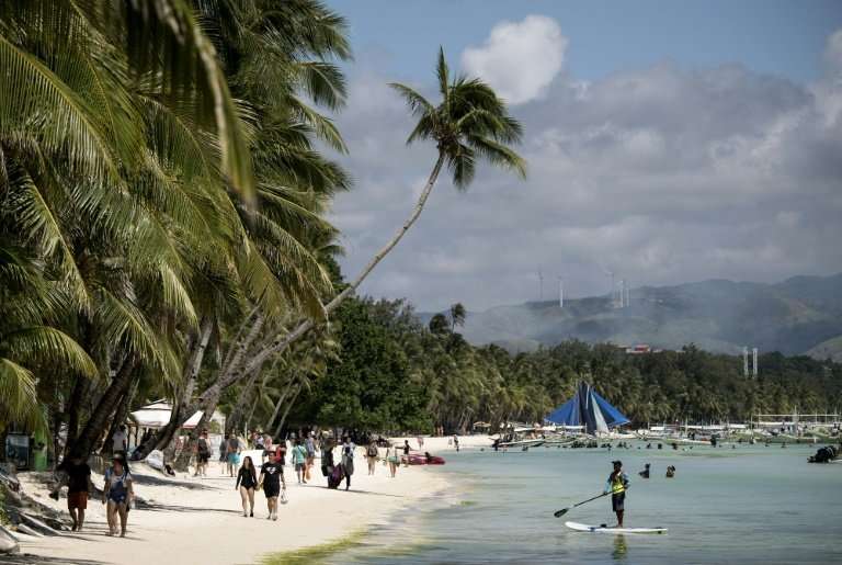 Tourists at the white sand beach of Boracay before its closure