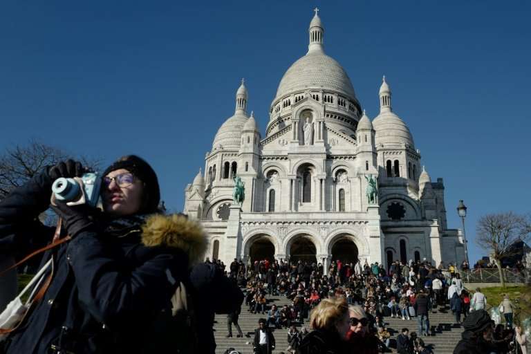 Tourists throng the steps outside the Sacre Coeur basilica in Paris' iconic Montmartre district, an area at risk of being swampe