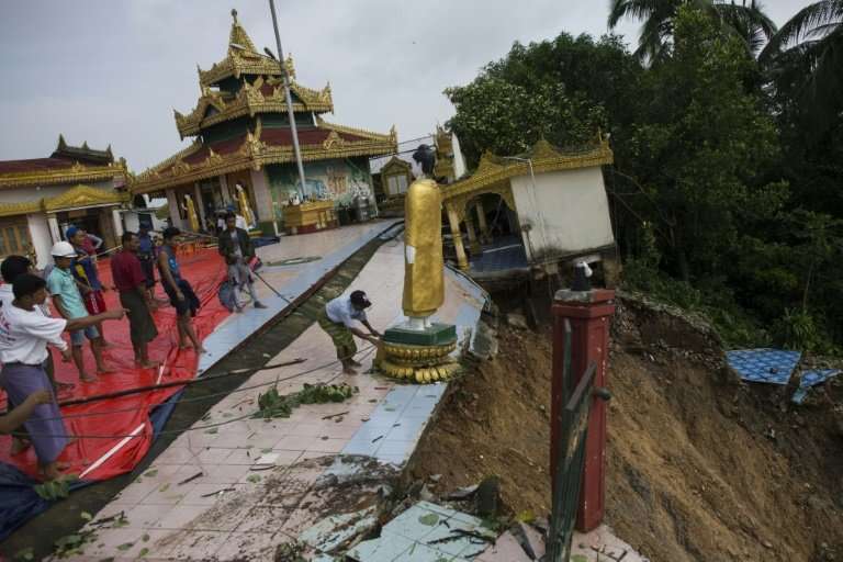 Workers are helping to relocate Buddha statues from a pagoda in Mawlamyine that was damaged in a landslide