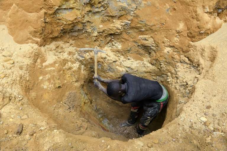 Young men dig with pickaxes in the hope of finding gold in the Cameroon town of Betare Oya