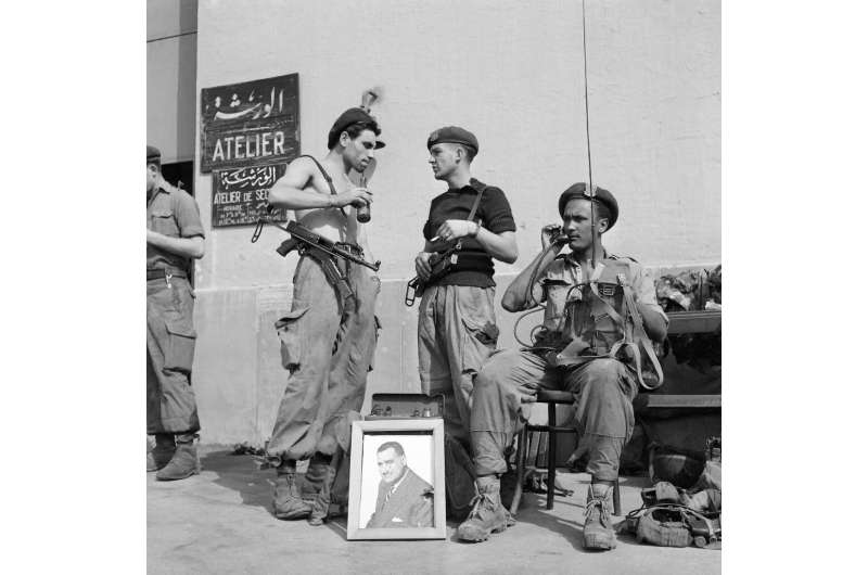 A file photo from November 1, 1956 shows Egyptian soldiers with a portrait of then president Gamal Abdel Nasser in Port Said at 
