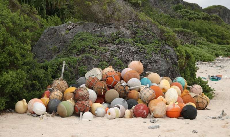 A pile of collected fishing bouys on a beach on Henderson Island, an uninhabited part of the Pitcairn archipelago in the South P