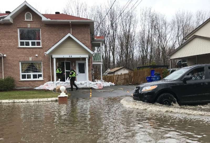 Firefighters check on people in their homes in preparation for increased flooding in Gatineau, Quebec