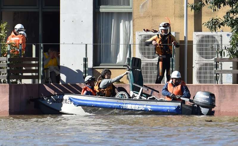 Rescuers moved people by boat from a retirement home that was flooded after Typhoon Hagibis hit Japan