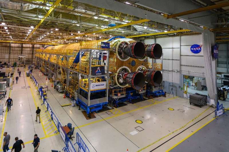 This NASA image obtained December 9, 2019 shows engineers and technicians as they attach the last of four RS-25 engines that wil