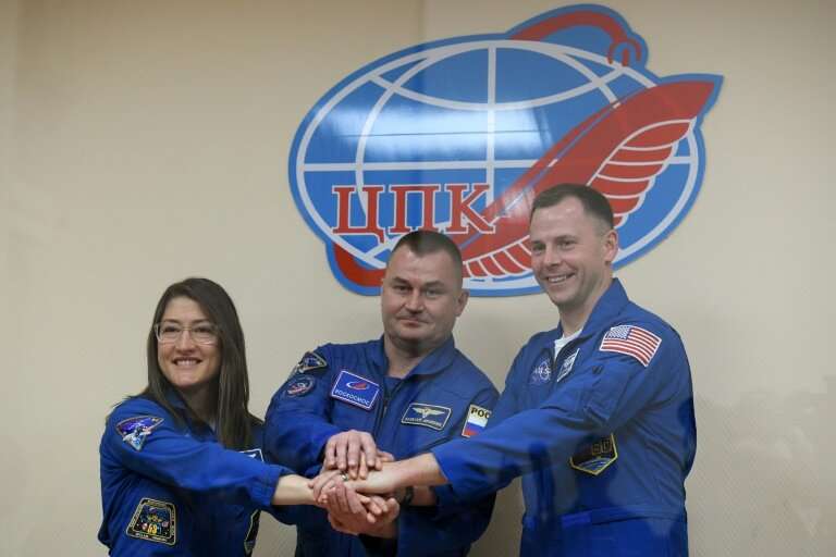 US astronauts Christina Hammock Koch (left) and Nick Hague (right) together with Russian colleague  Alexey Ovchinin are due to b