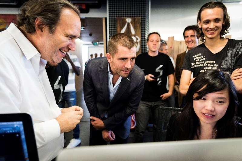 Facebook Chief Product Officer Chris Cox (C) listens to Xavier Niel (L), French businessman and founder of the French telecom an