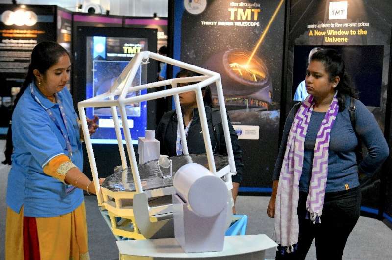 Visitors look at a scaled down model of the Thirty Meter Telescope (TMT) on display during a science exhibition in Bangalore in 