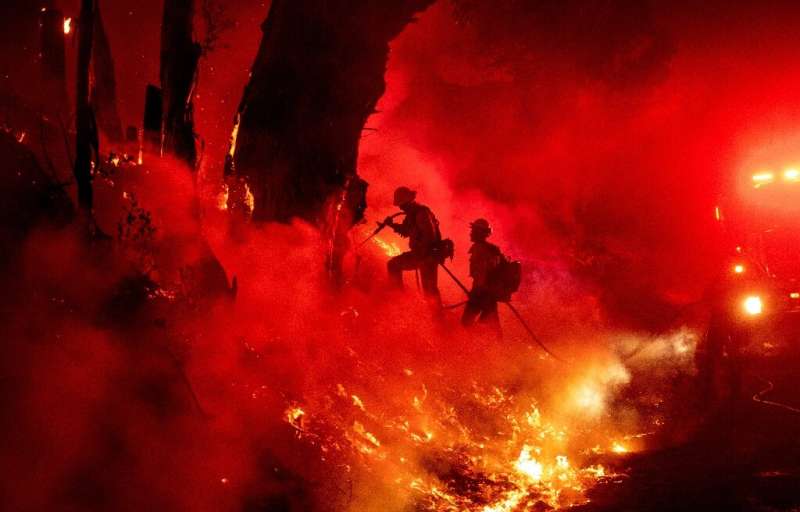 Firefighters try to control one of the fires in  California this month.Such blazes are intensifying due to climate change