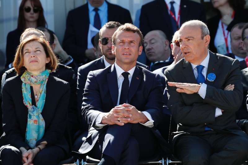 French President Emmanuel Macron sits between Defence Minister Florence Parly, left, and Dassault Aviation chief executive Eric 