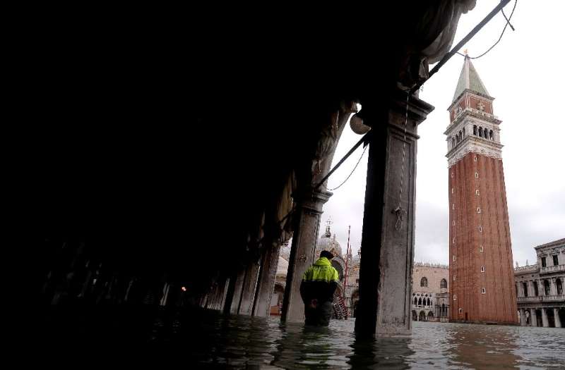 Schools reopened in Venice as shopkeepers with mops and buckets in hand tried to muck out the water and mud that flooded their s